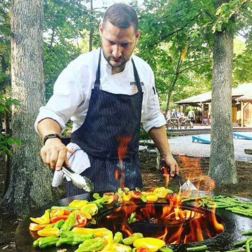 Grilling vegetables on the Arteflame 20" Tall Euro Base Corten Steel Fire Pit with Cooktop