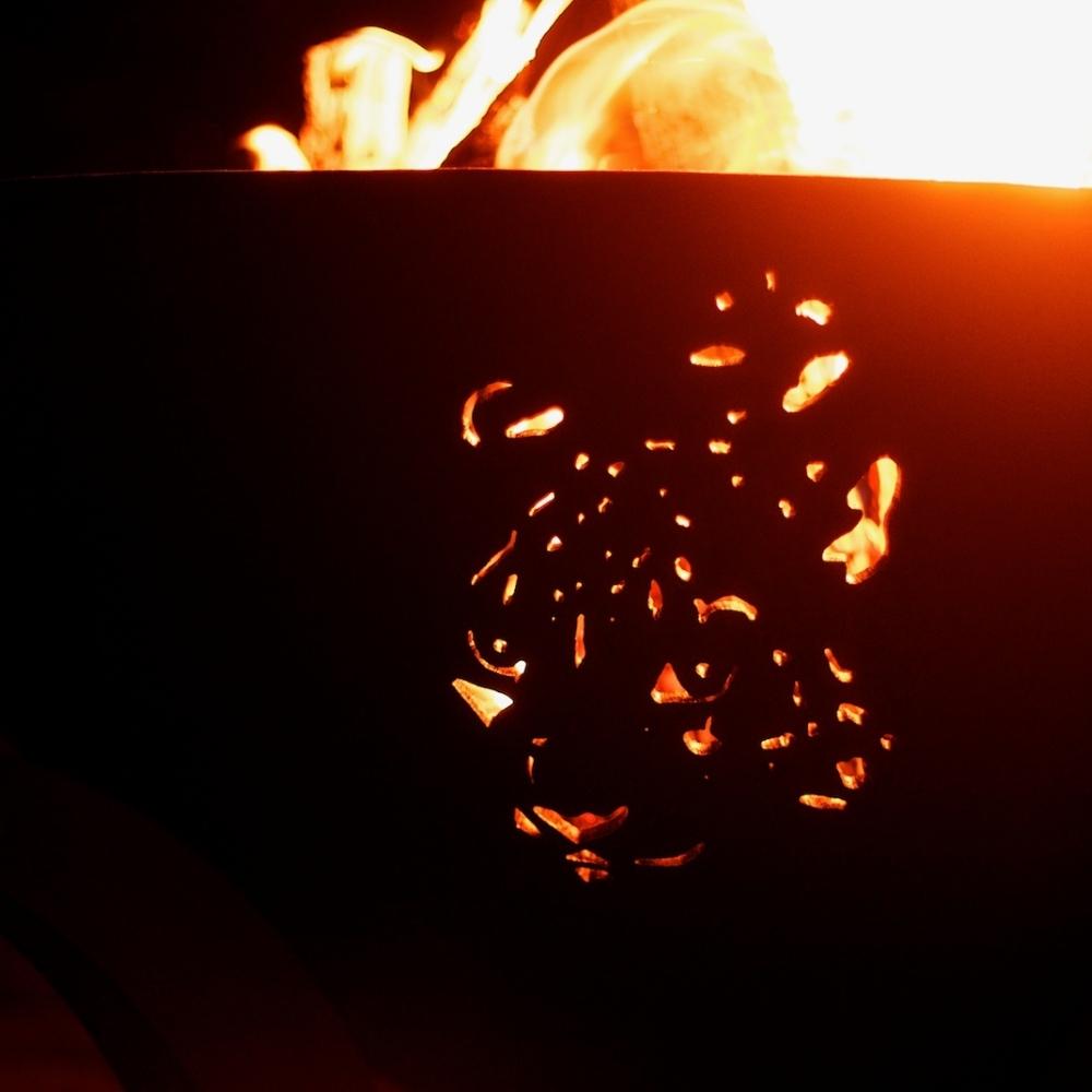 Leopard Design On The Inside of Fire Pit Art Africa's Big Five With Burning Logs - angle view