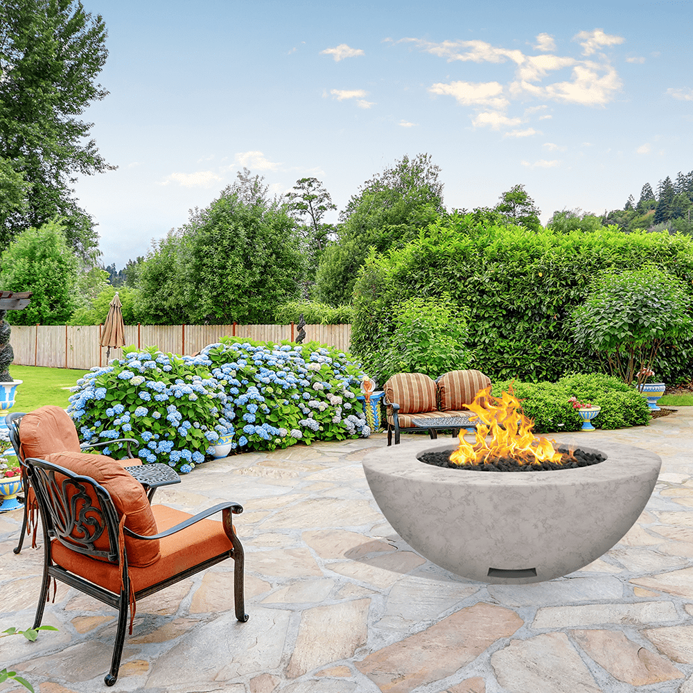modern blaze round ivory fire bowl with textured surface in a lush garden - angle view