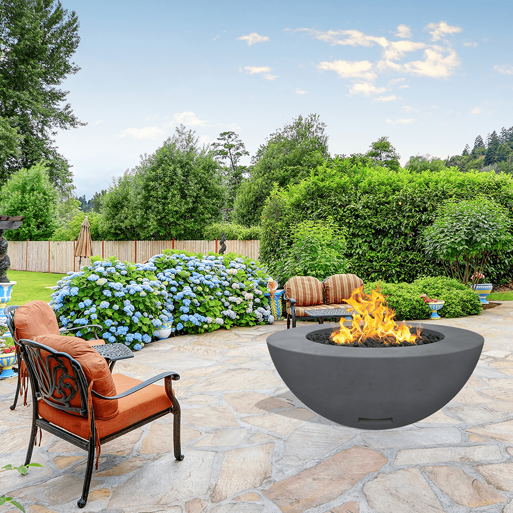 modern blaze round coal fire bowl with smooth surface in a lush garden - angle view