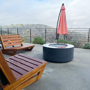gray round fire pit table in a view overlooking the mountains