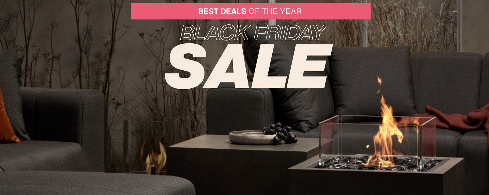 Concrete-walled space with black couches, ethanol fire pit in the center