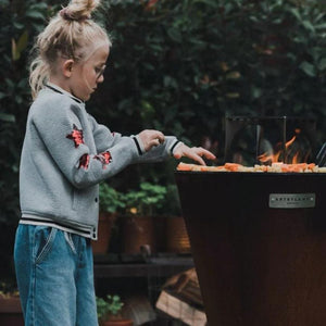 a kid grilling on the arteflame one series 20-inch fire pit