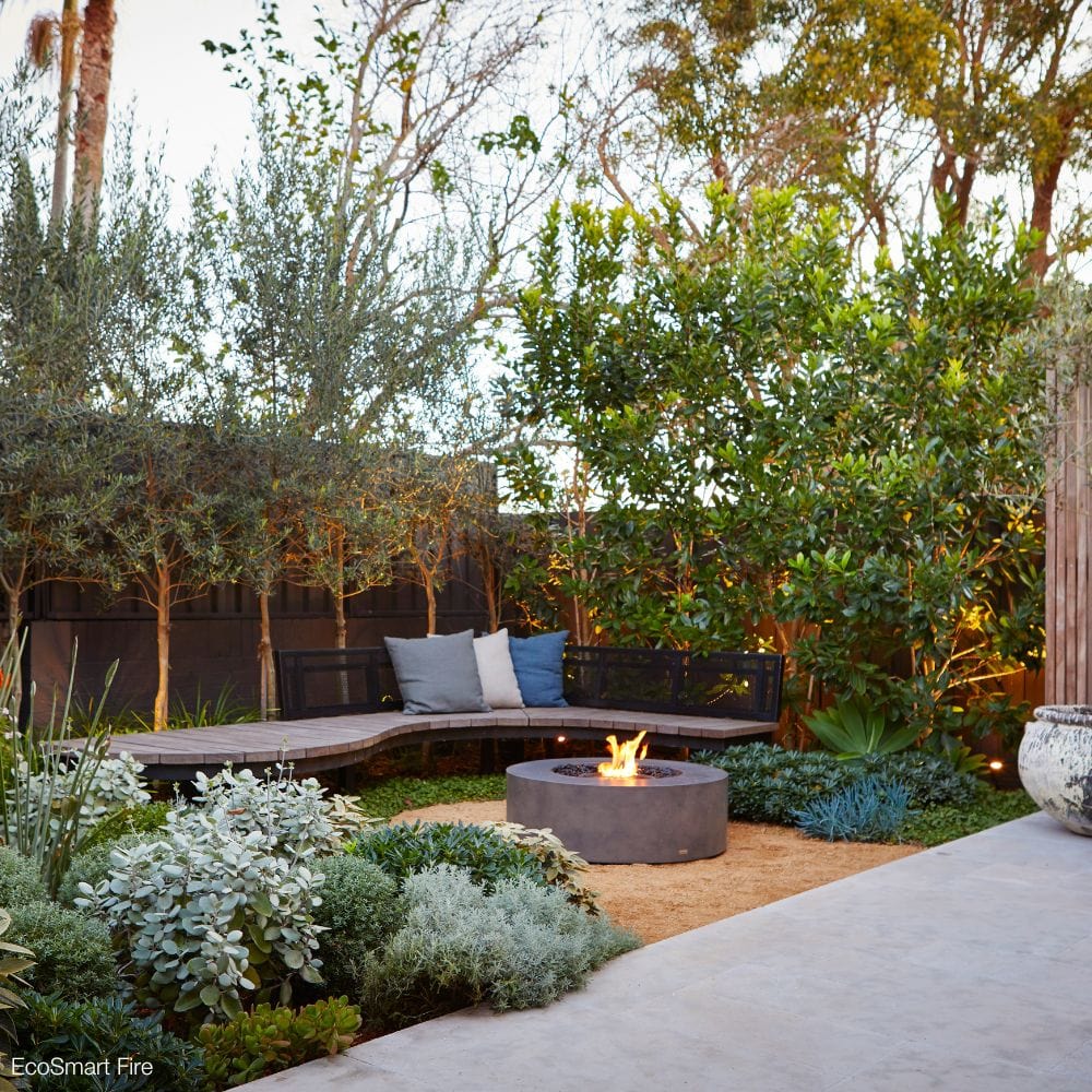 ecosmart fire ark gray fire pit table in a garden