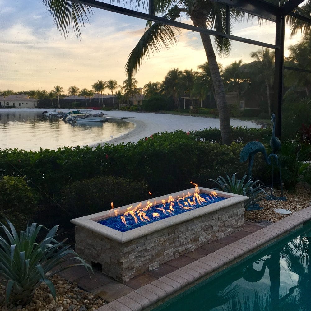 HPC H-Burner Gas Fire Pit Insert installed on a linear fire pit by the lake - side view