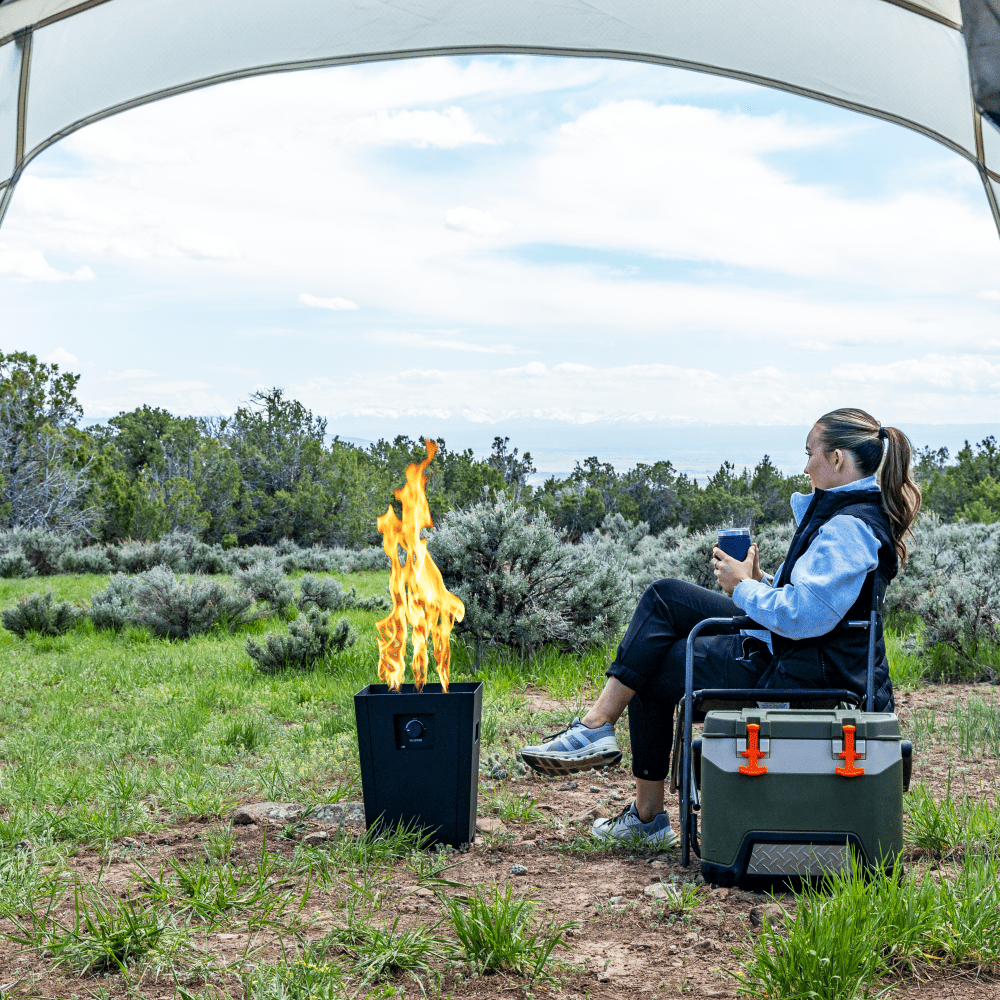 Live Outdoor Firestorm Series I Free Standing Fire Pit with the Burner On at an Outside Campsite Amidst Beautiful Scenery