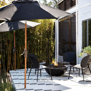 black modern blaze gas fire bowl in a contemporary patio with black umbrellas
