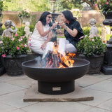 enjoying a glass of wine by the seasons fire pits elliptical steel fire pit