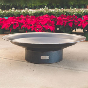 Seasons Fire Pits Flare Round Steel Fire Pit in a garden