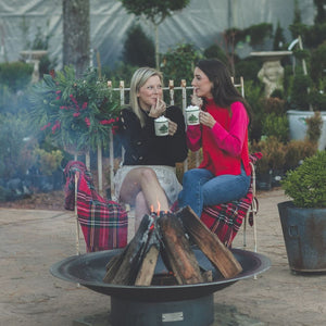 enjoying a cup of hot cocoa by the seasons fire pits flare steel fire pit