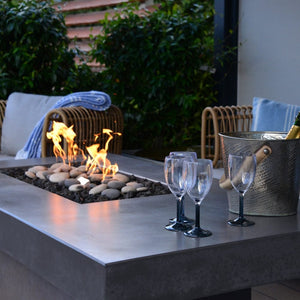 Wine Glasses on the Solus Tavolo 68-Inch Linear Concrete Gas Fire Pit Table