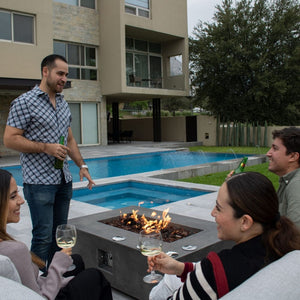 gathering in the pool area with a fire pit table