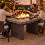 Couples toasting at a dinner party around a Top Fires Alameda 72-inch composite wood gas fire table with a Summit tabletop and Copper Vein base