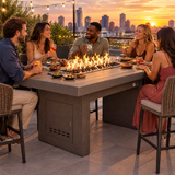 Friends enjoying tapas and cocktails on a rooftop terrace around a Top Fires Alameda 72-inch composite wood gas fire table with a Tacoma tabletop and Copper Vein base