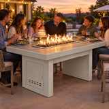 Family celebrating a birthday dinner on a poolside patio around a Top Fires Alameda 72-inch composite wood gas fire table with a Tacoma tabletop and White base