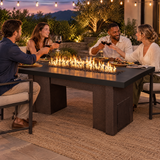 Couples toasting at a dinner party around a Top Fires Alameda 72-inch GFRC gas fire table with a Smooth Black tabletop and Copper Vein base
