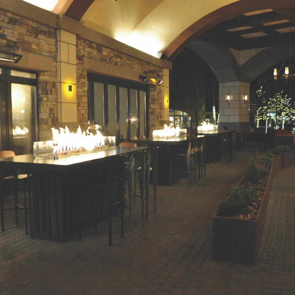 Warming Trends Linear CROSSFIRE™ Brass Burners in Outdoor Dining Area
