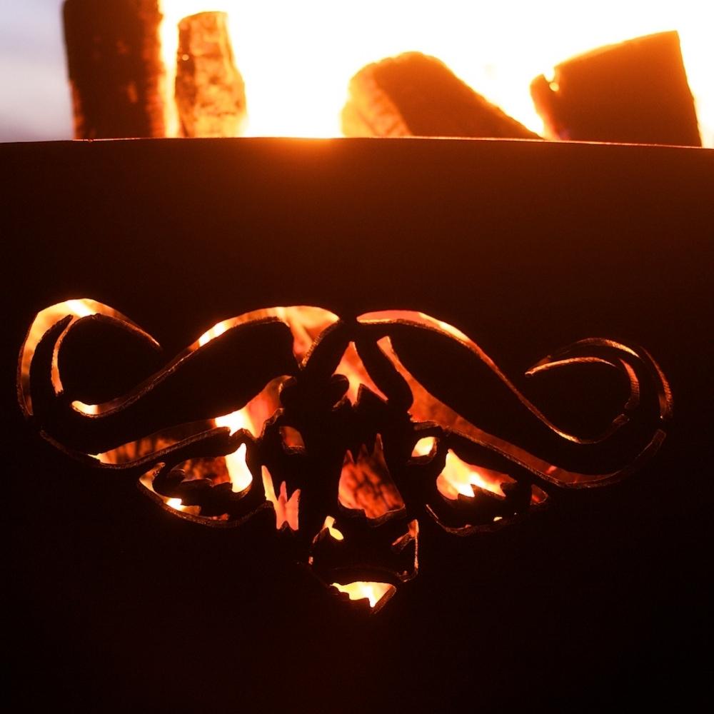 Cape Buffalo Design of Fire Pit Art Africa's Big Five With Burning Logs - angle view