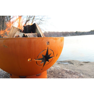 Fire Pit Art Navigator - 36" Handcrafted Carbon Steel Fire Pit (NAV) Lit Up Beside A Lake