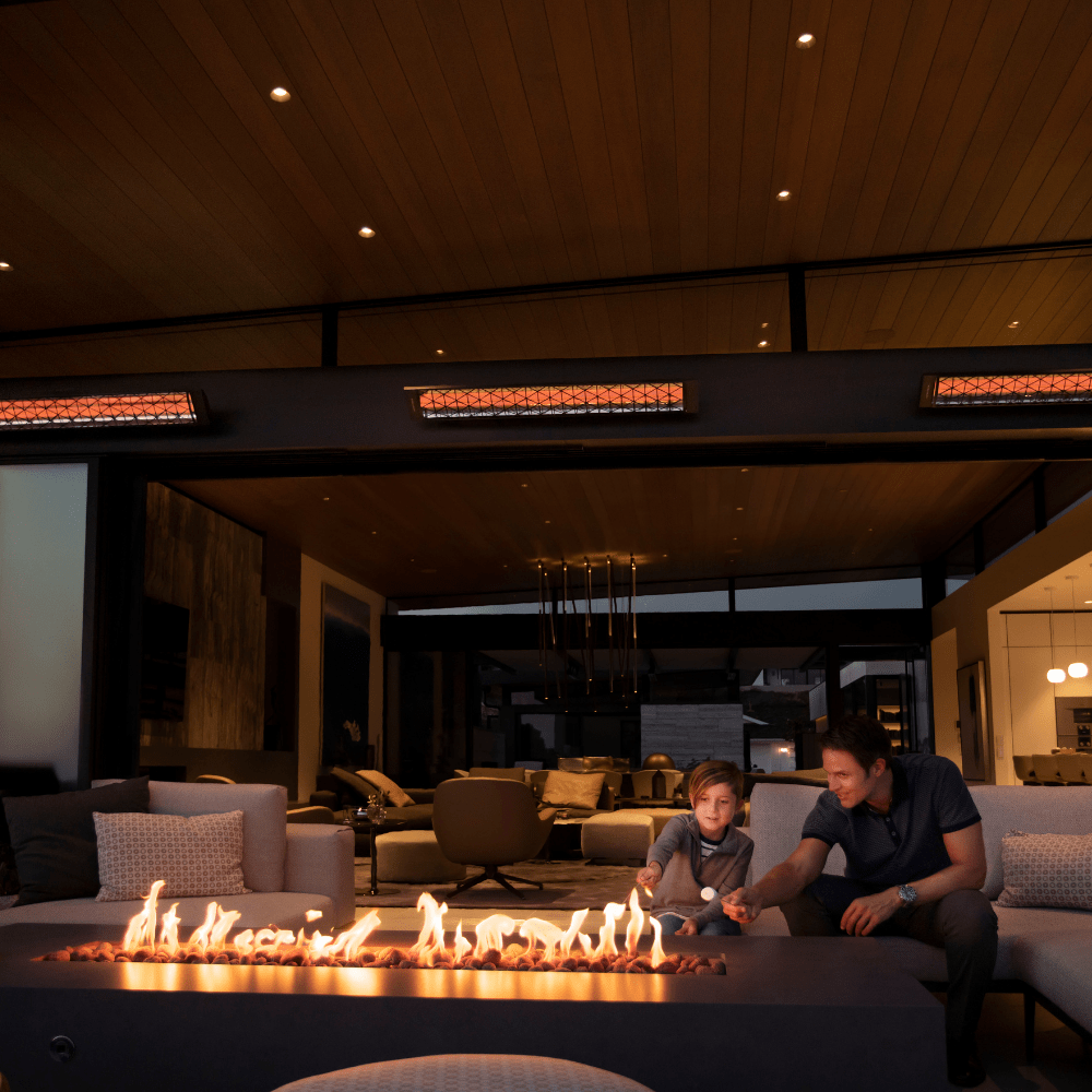 father and son enjoying the heat of their infratech cd electric patio heaters