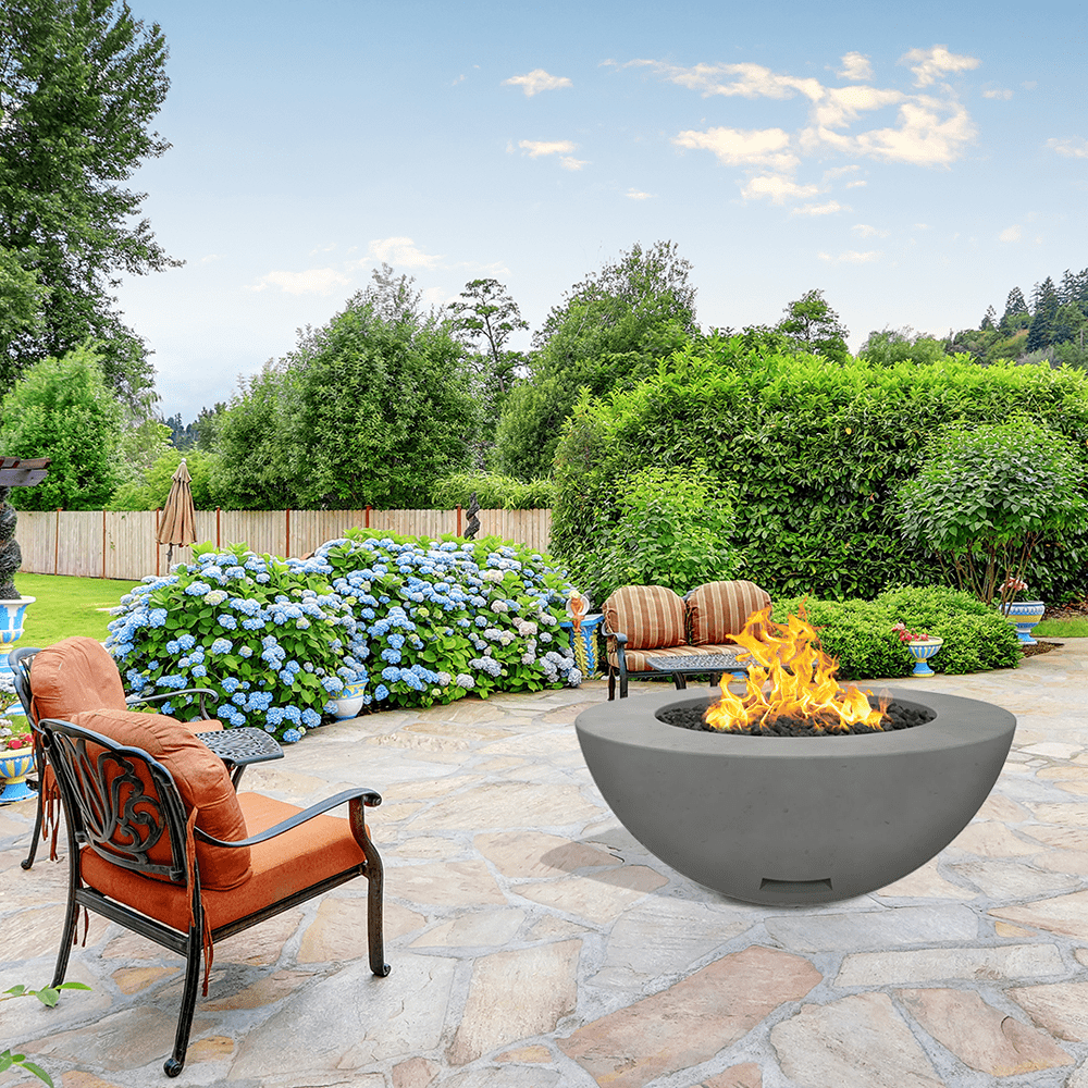 modern blaze round slate fire bowl with smooth surface in a lush garden - angle view