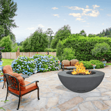modern blaze round coal fire bowl with smooth surface in a lush garden - angle view