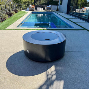 black fire pit table by the pool in a contemporary backyard