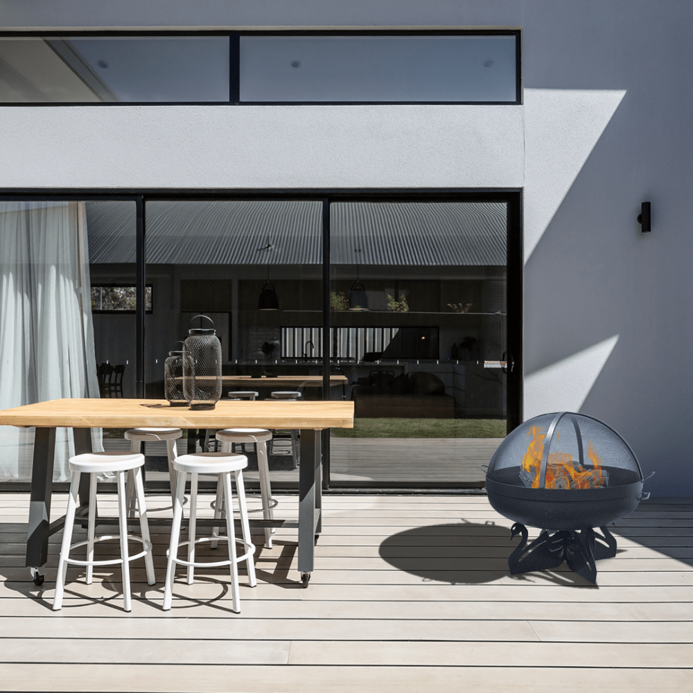 modern blaze round swan base steel fire pit in a cozy patio dining area