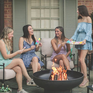friends gathering around the seasons fire pits elliptical round fire pit