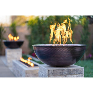 several sedona 27-inch round copper gas fire bowls at the backyard
